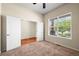 Bedroom showcasing an open closet with white doors and a window view to the outside at 15414 Xenia Ct, Thornton, CO 80602