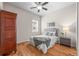 Bedroom with hardwood floors, ceiling fan, wardrobe, and a bed with tufted headboard and patterned pillows at 15414 Xenia Ct, Thornton, CO 80602