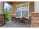 Inviting front porch with stone accents, outdoor seating, and views of the surrounding landscape at 15414 Xenia Ct, Thornton, CO 80602