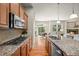 Well-lit kitchen with granite countertops, stainless steel appliances, and an open view to the living room at 15414 Xenia Ct, Thornton, CO 80602