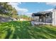 Spacious backyard with a wooden fence, large green space, and backyard patio at 4933 S Xenon Ct, Morrison, CO 80465