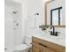 Bathroom features white cabinets with a vanity, framed mirror, and a glass-enclosed shower at 4933 S Xenon Ct, Morrison, CO 80465