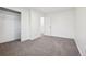 A bright bedroom features gray carpet, white walls, and an open closet space at 4933 S Xenon Ct, Morrison, CO 80465