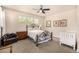 Cozy bedroom featuring a wrought iron bed, a ceiling fan, and natural light from three windows at 11857 S Saunter Ln, Parker, CO 80138