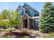 Inviting home entrance with a stone archway, mature trees, and colorful landscaping creating a warm welcome at 11857 S Saunter Ln, Parker, CO 80138
