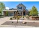 Charming two-story home with stone accents, a covered entrance, professional landscaping, and an attached two-car garage at 11857 S Saunter Ln, Parker, CO 80138