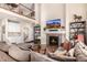 Spacious living room with soaring ceilings, stone fireplace, and an adjacent wet bar for seamless entertaining at 11857 S Saunter Ln, Parker, CO 80138