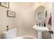 Cozy powder room featuring pedestal sink and decorative mirror at 11857 S Saunter Ln, Parker, CO 80138