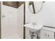 Bathroom featuring a pedestal sink, a walk-in shower, and white wainscoting at 1748 S Logan St, Denver, CO 80210