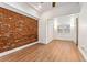 Spacious bedroom featuring wood floors, a brick wall, and an attached seating area at 1748 S Logan St, Denver, CO 80210
