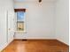 Bright bedroom featuring hardwood floors, white walls and trim, and a window providing natural light at 1748 S Logan St, Denver, CO 80210