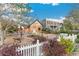 Front exterior of a charming home with creative rock landscaping, mature trees, and white picket fence at 1748 S Logan St, Denver, CO 80210