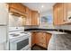Bright kitchen features light wood cabinets, black countertops, and a white range oven at 1748 S Logan St, Denver, CO 80210
