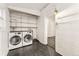 Equipped laundry room with washer, dryer, shelving, and white brick accents for convenient home chores at 1748 S Logan St, Denver, CO 80210