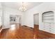 Spacious living room featuring hardwood floors, built-in shelving, and an archway to another room at 1748 S Logan St, Denver, CO 80210