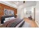 Staged main bedroom featuring wood floors, a brick wall, and a sitting area at 1748 S Logan St, Denver, CO 80210