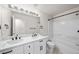 Bright bathroom featuring double sinks, white cabinets, and shower over tub at 15612 E 96Th Way # 20H, Commerce City, CO 80022