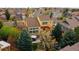 Aerial view of a yellow two-story house with a backyard patio and mature trees at 25362 E Indore Dr, Aurora, CO 80016
