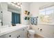 Bright bathroom with a modern vanity, updated fixtures and shower with blue curtain at 25362 E Indore Dr, Aurora, CO 80016