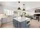Bright kitchen featuring a gray island, stainless steel appliances, and an open layout to the dining area at 25362 E Indore Dr, Aurora, CO 80016