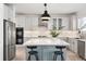 Bright kitchen with white cabinets, stainless steel appliances, and a blue island with a white countertop at 25362 E Indore Dr, Aurora, CO 80016