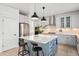 A bright kitchen with a large island, pendant lighting, white cabinetry, and stainless steel appliances at 25362 E Indore Dr, Aurora, CO 80016