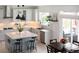 Well-lit kitchen featuring white cabinets, patterned backsplash, stainless steel appliances, and an island with seating at 25362 E Indore Dr, Aurora, CO 80016