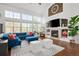 Spacious living room with large windows, a fireplace, modern furnishings, and hardwood floors at 25362 E Indore Dr, Aurora, CO 80016