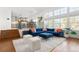 Bright living room featuring modern blue sofa and view into the kitchen and dining area at 25362 E Indore Dr, Aurora, CO 80016