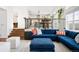 Open-concept living room with a plush blue sofa and seamless view into the dining area and kitchen at 25362 E Indore Dr, Aurora, CO 80016