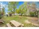 Spacious backyard featuring a large grassy area, mature trees, and storage shed at 113 E Saint Clair Ave, Longmont, CO 80504