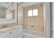 Tiled bathroom featuring a shower-tub combination with a window and vanity with granite countertop at 113 E Saint Clair Ave, Longmont, CO 80504