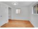 Bright bedroom featuring hardwood floors, a closet, and natural light from a window at 113 E Saint Clair Ave, Longmont, CO 80504