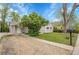 Well-maintained gray home featuring a gravel driveway, lush lawn, and mature landscaping at 113 E Saint Clair Ave, Longmont, CO 80504