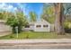 Charming gray single-story home featuring a lush front yard with mature trees and appealing landscaping at 113 E Saint Clair Ave, Longmont, CO 80504