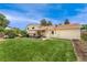 Spacious backyard showcasing a well-kept lawn, a charming patio with an awning, and mature landscaping at 8475 W 74Th Dr, Arvada, CO 80005