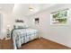 Cozy bedroom featuring a plaid comforter, white walls, carpeted floors, and natural light from two windows at 8475 W 74Th Dr, Arvada, CO 80005