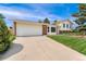 Inviting two-story home with a well-maintained lawn, a brick facade, and an attached two-car garage at 8475 W 74Th Dr, Arvada, CO 80005