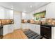 Bright kitchen with white cabinetry, black appliances, and stylish backsplash at 8475 W 74Th Dr, Arvada, CO 80005