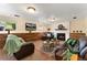 Cozy living room with a fireplace, wood paneling, and comfortable leather furniture at 8475 W 74Th Dr, Arvada, CO 80005