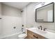 Updated bathroom features a sleek vanity with modern fixtures and a white-tiled shower/tub at 9272 E Mansfield Ave, Denver, CO 80237