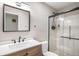 Bathroom with modern vanity, walk-in shower with glass, bright light and neutral colors at 9272 E Mansfield Ave, Denver, CO 80237