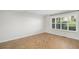 A bright bedroom features wood-look herringbone floors and large window at 9272 E Mansfield Ave, Denver, CO 80237