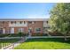 Charming brick townhome featuring a well-maintained lawn and landscaped front yard at 9272 E Mansfield Ave, Denver, CO 80237