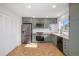 Renovated kitchen with stainless appliances, shaker cabinets, wood counters and herringbone floors at 9272 E Mansfield Ave, Denver, CO 80237