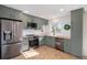 Modern kitchen featuring updated appliances, wood countertops, shaker cabinets, and herringbone floors at 9272 E Mansfield Ave, Denver, CO 80237