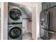 Efficient laundry area featuring a stacked washer/dryer next to the kitchen refrigerator at 9272 E Mansfield Ave, Denver, CO 80237