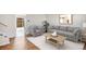 Bright living room with wood floors, gray sofa and chair, art, and a decorative coffee table at 9272 E Mansfield Ave, Denver, CO 80237
