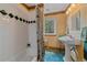 Bathroom features a pedestal sink, a bathtub with shower, and a window at 27612 Shadow Mountain Dr, Conifer, CO 80433