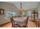 Elegant dining room with hardwood floors, large windows overlooking a wooded yard, and classic furnishings at 27612 Shadow Mountain Dr, Conifer, CO 80433